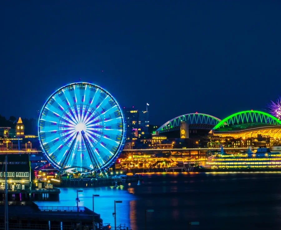 Seattle Great Wheel lit up at night with waterfront views