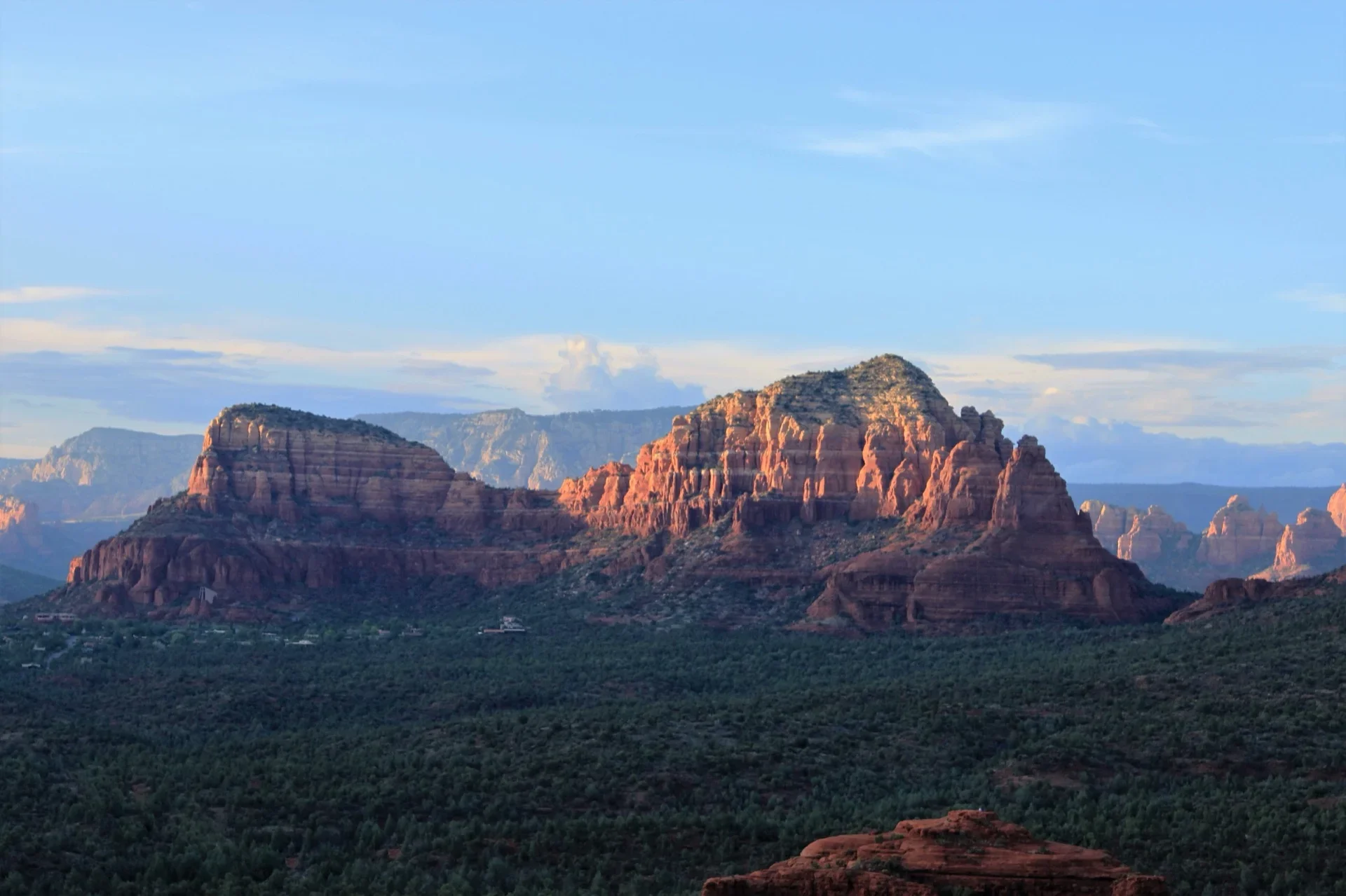 Couple climbing Cathedral Rock trail with panoramic red rock views