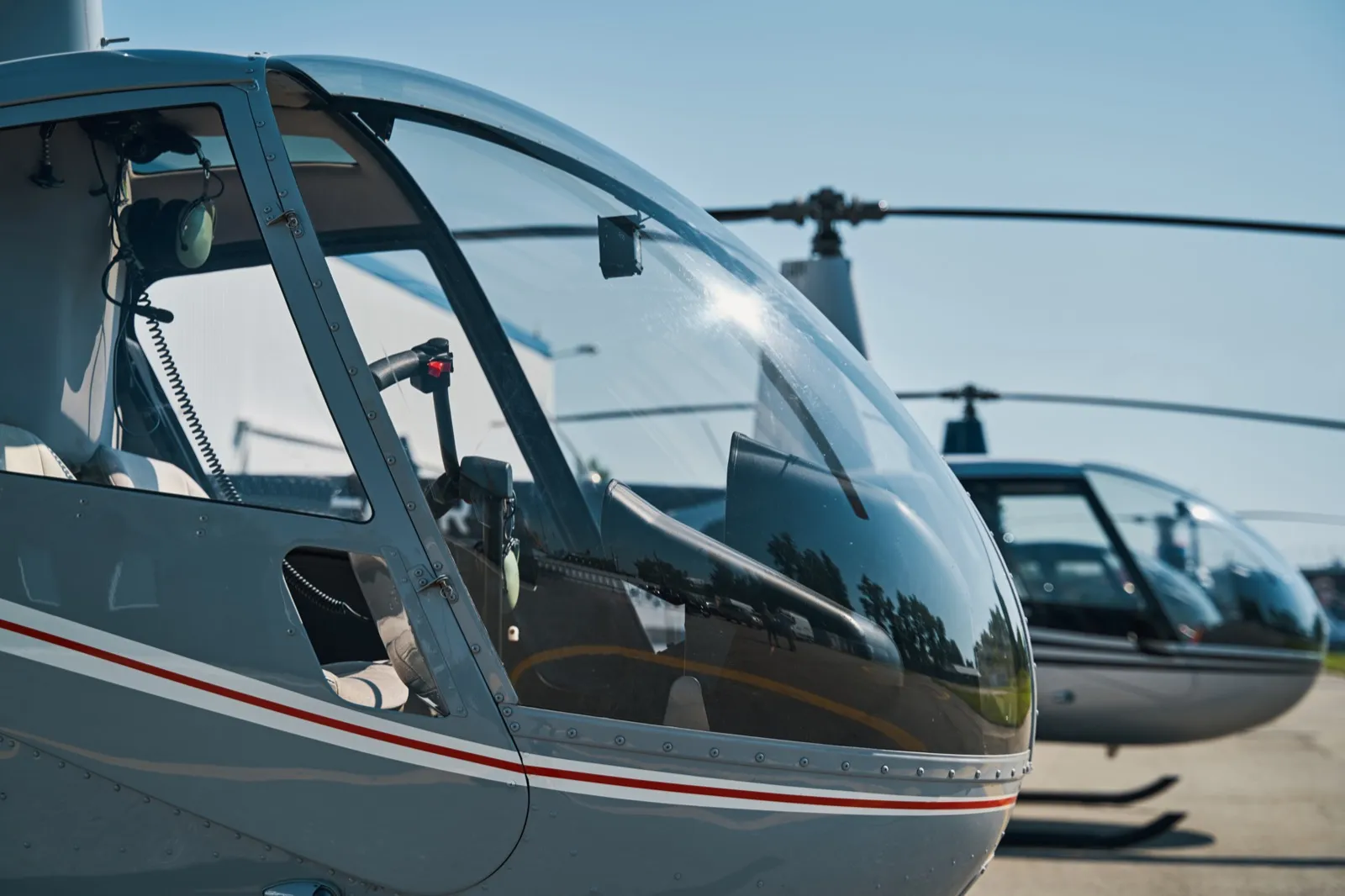Civilian helicopters parked on a concrete helipad before a NYC sightseeing tour