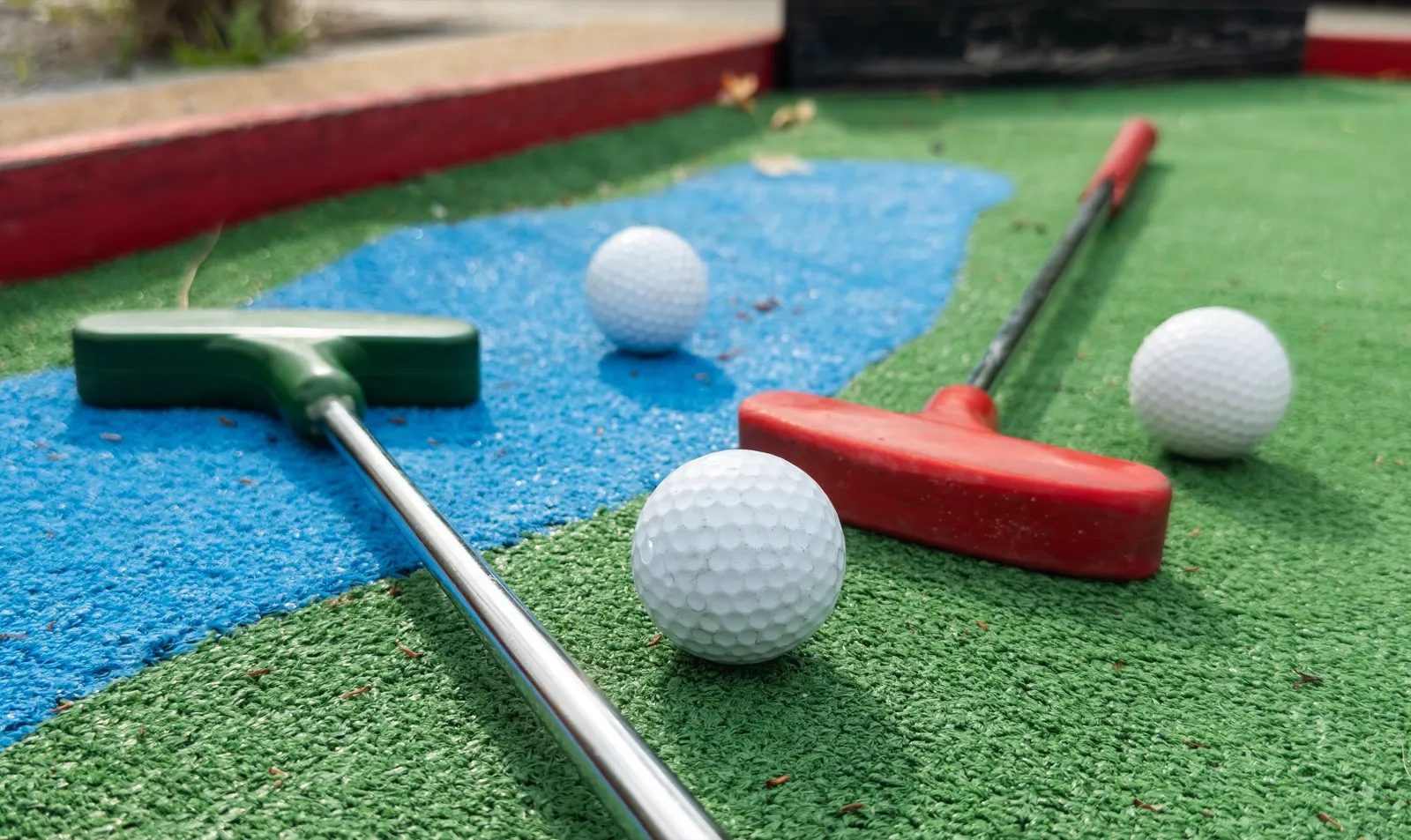 Couple playing mini golf on a date night