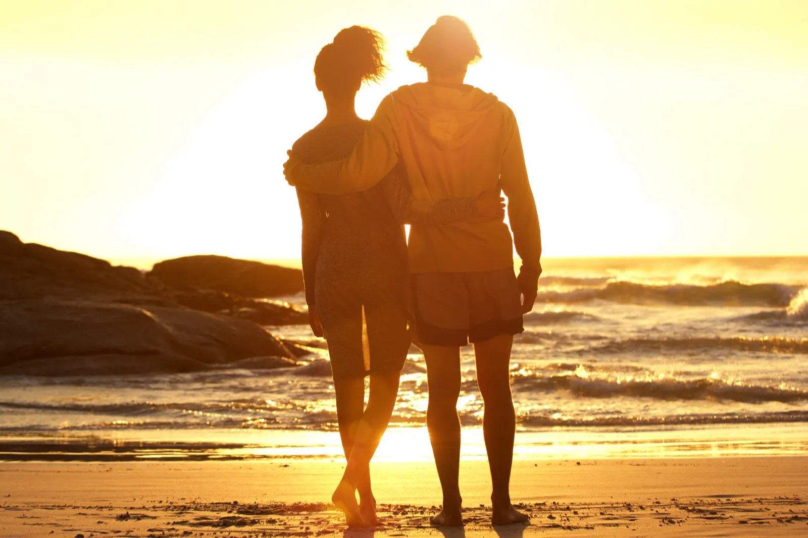 Couple watching the sunrise at Lanikai Beach with the Mokulua Islands in the distance