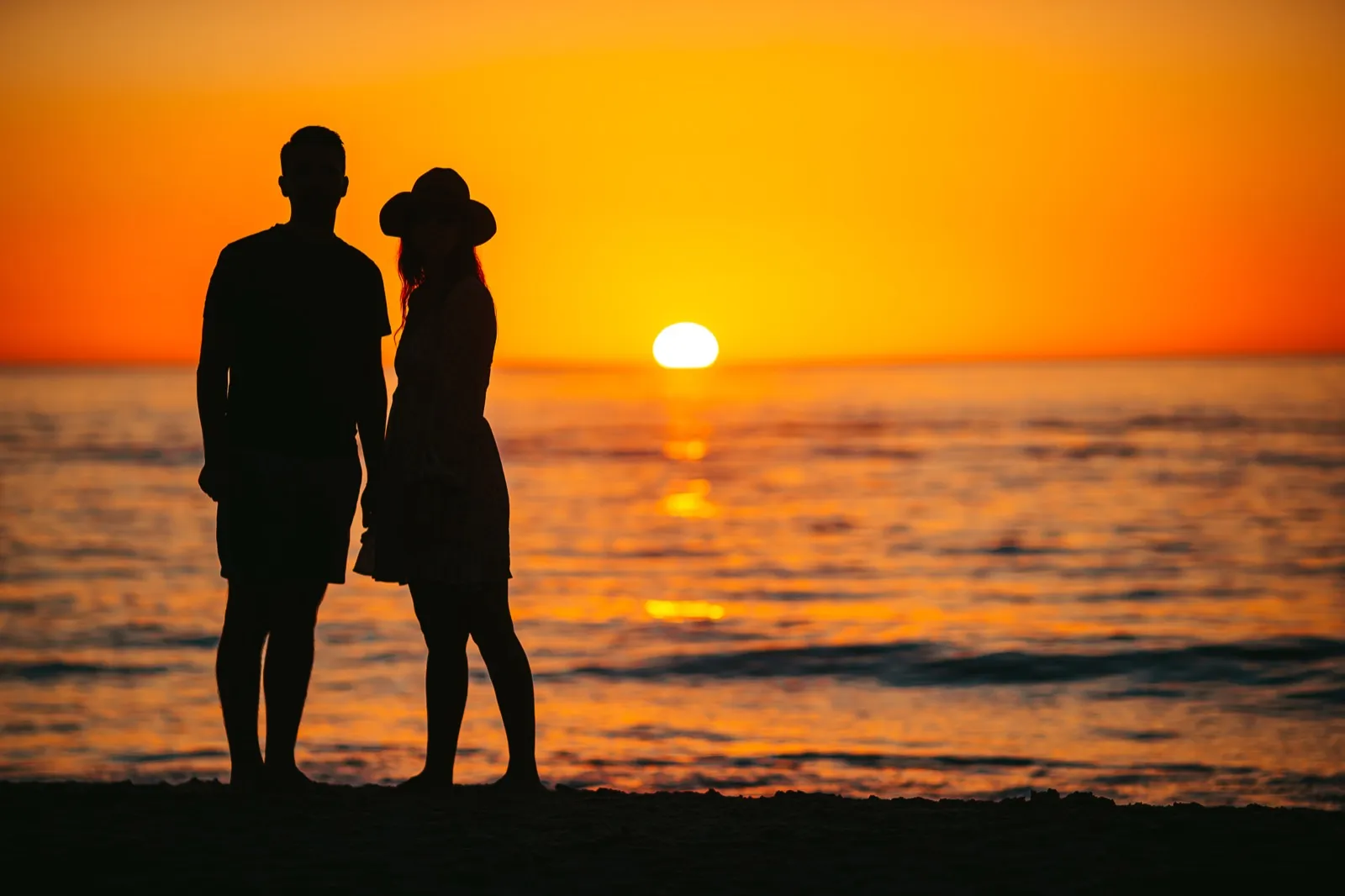 Couple on romantic free date photographing golden hour sunset