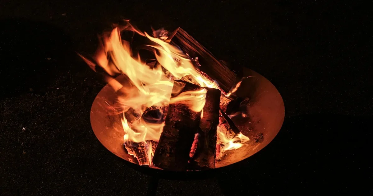 Couple enjoying a romantic beach bonfire at sunset