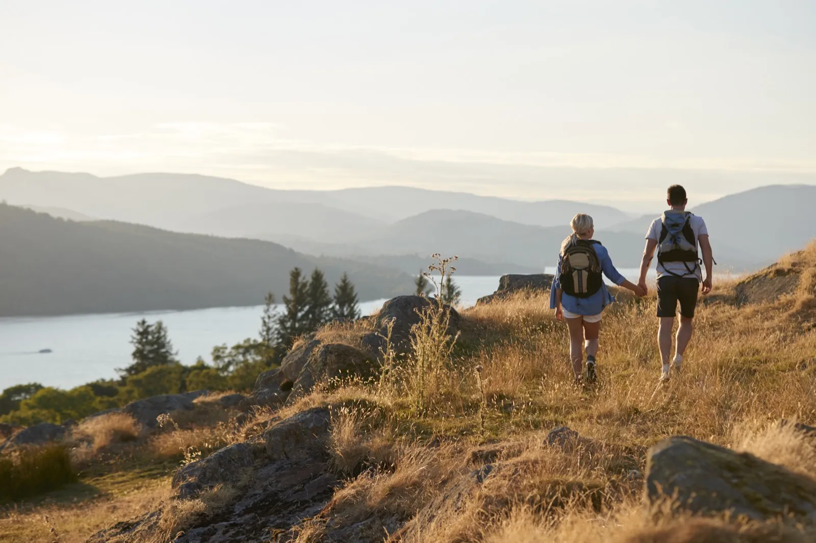 Couple hiking to a mountain summit date