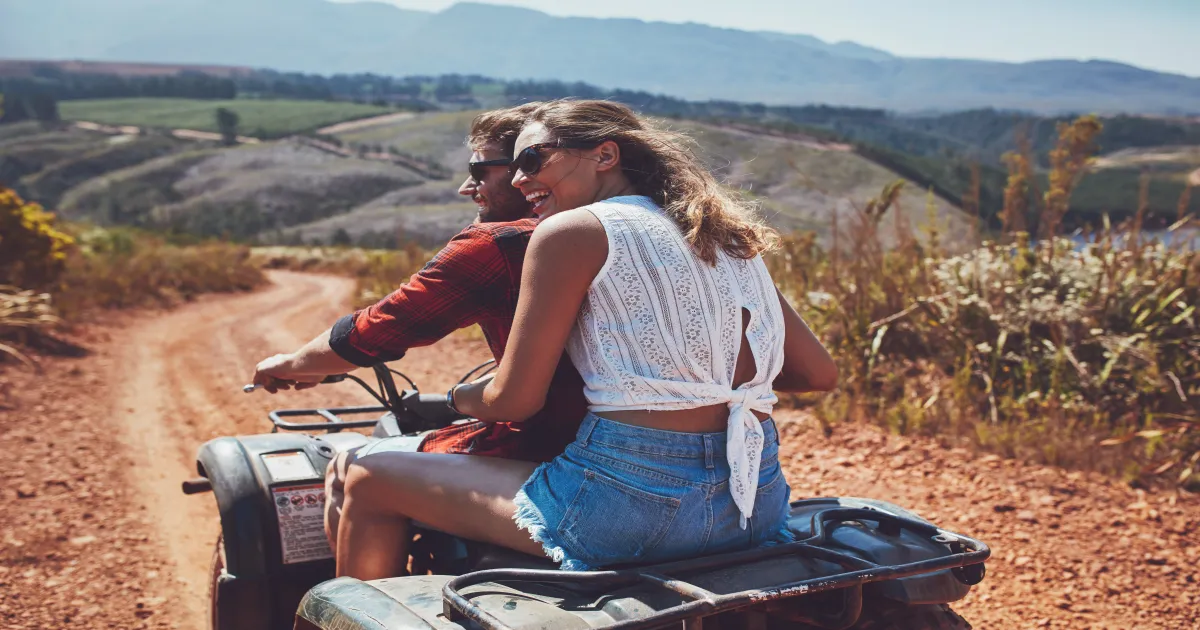Couple riding ATVs through desert terrain near Sedona red rocks