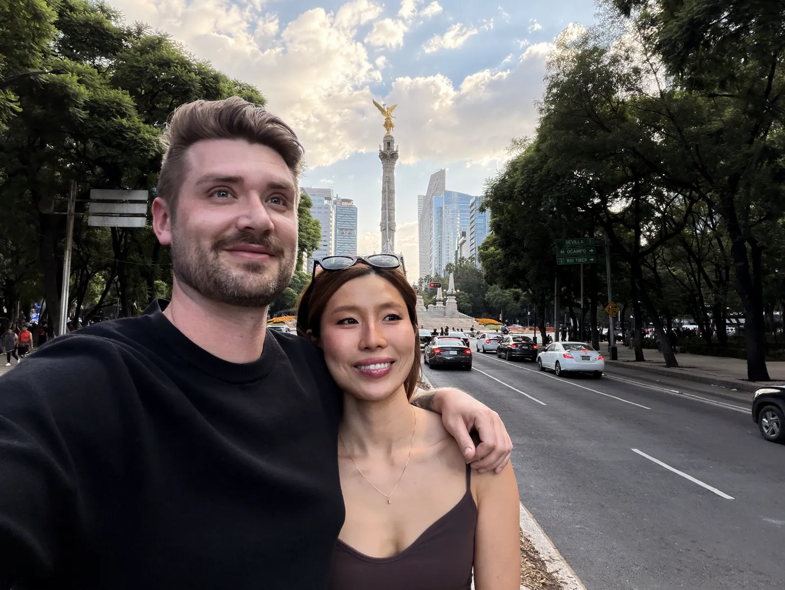Couple on Paseo de la Reforma with the Angel of Independence monument in the background