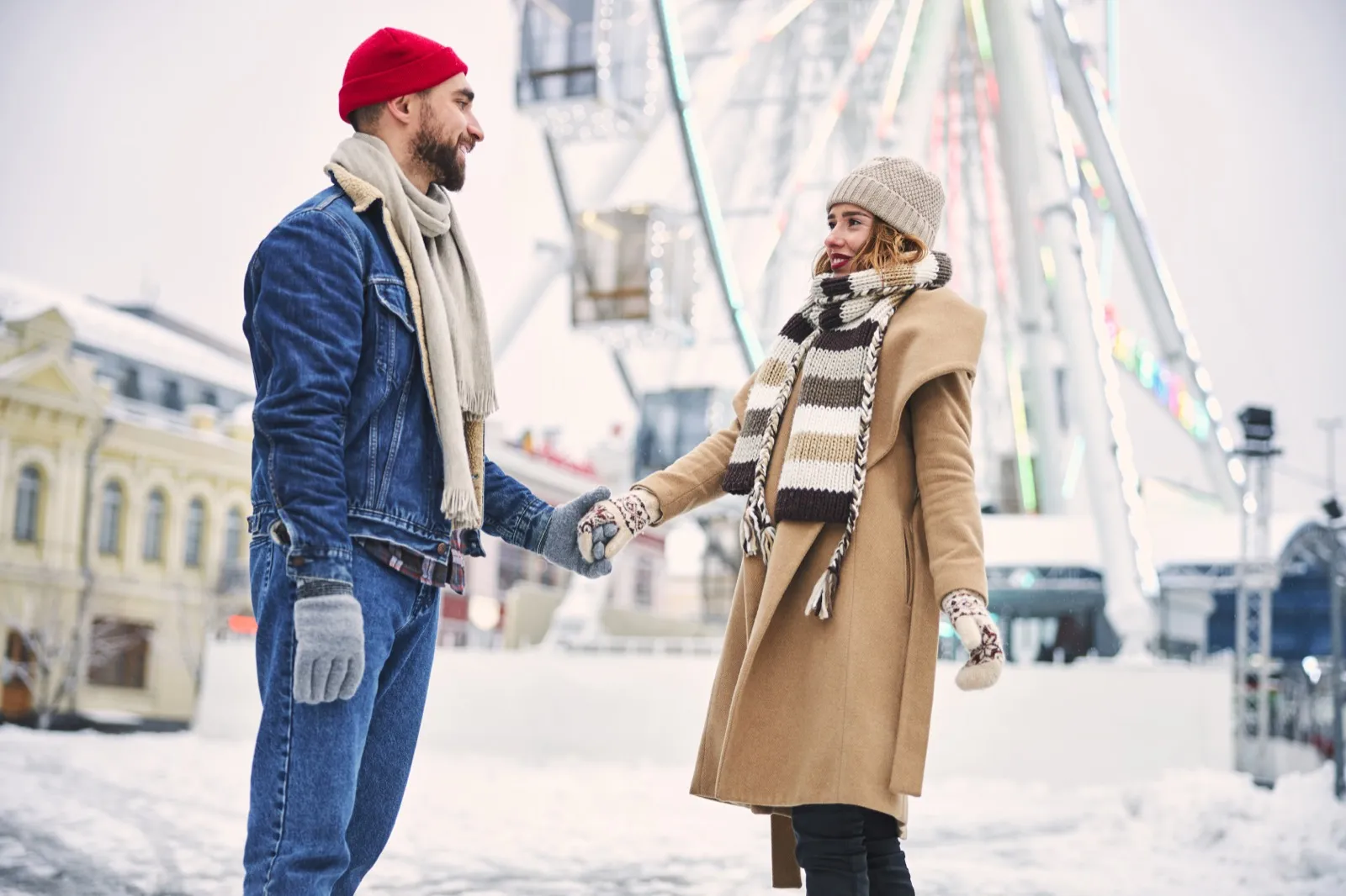 Couple enjoying winter date outdoors with snow and twinkling lights - creative winter date ideas