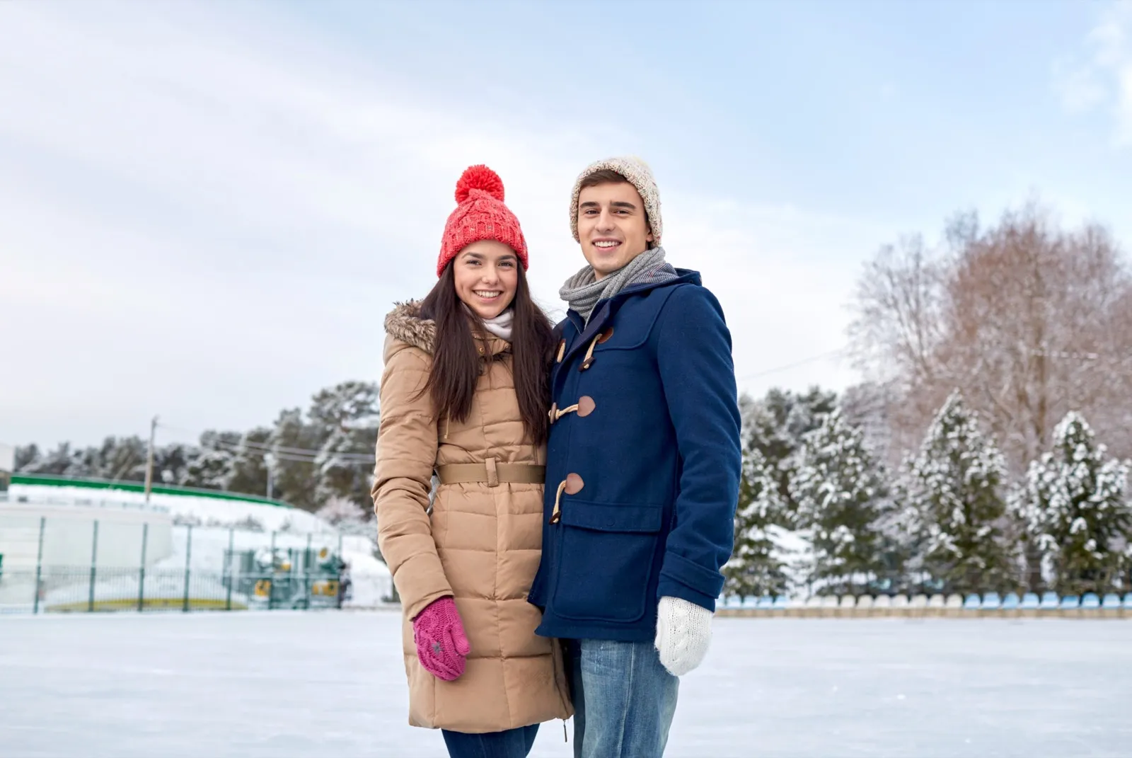 Couple ice skating together under winter lights - outdoor winter date activity